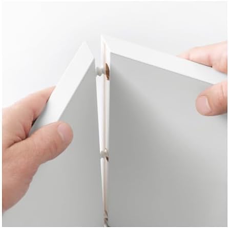 Close-up of two hands connecting two white cabinet panels using a dowel pin