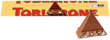 Caixa amarela do chocolate Toblerone ao leite com nougat de mel e amêndoas, exibindo o logo e duas metades de chocolate triangular.