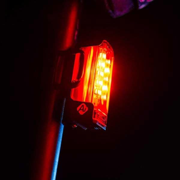 LEZYNE Strip Pro AI Alert 400+ Rear Light illuminated on a bicycle seatpost at night.