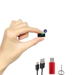 Hand holding miniature camera with USB cables and pin