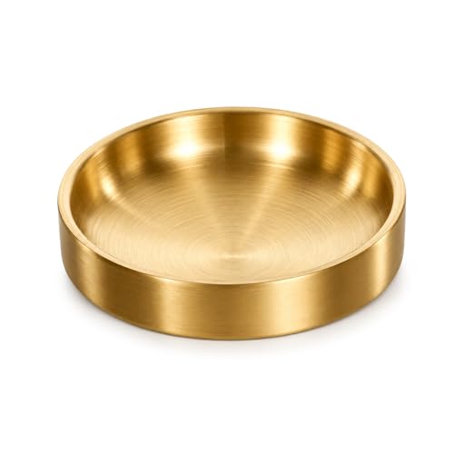 a small round gold dish holding a ring and a pair of earrings on a nightstand