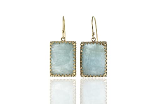 Boucles d'oreilles aigue marine pendantes contre le teint terne des femmes
