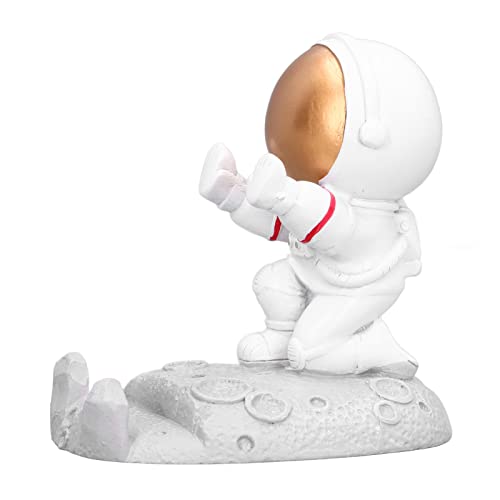 Soporte para teléfono y figura de astronauta dorado, un toque elegante en tu mesa