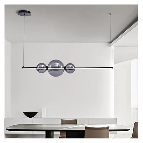 Table à manger éclairée par un lustre moderne en verre de style nordique