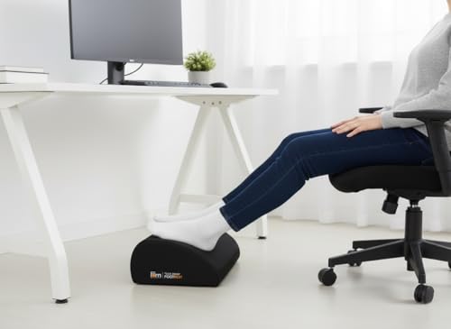 Person sitting in a chair with feet supported on a black footrest for chair meditation posture.