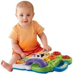 Child playing with VTech activity panel on floor