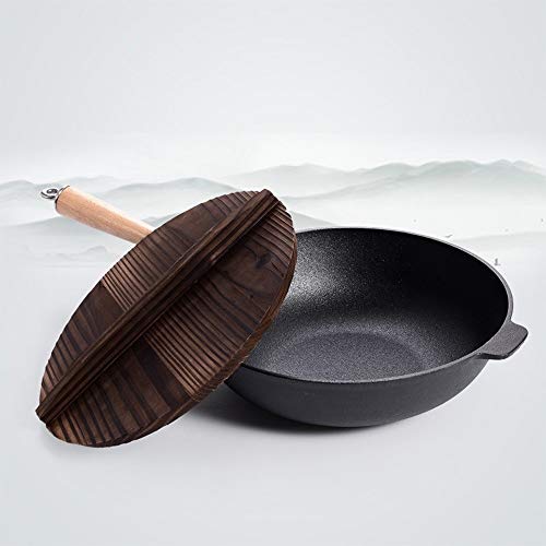 Olla tradicional de hierro fundido previamente con tapa de madera y sartén salteado que prepara deliciosos platos