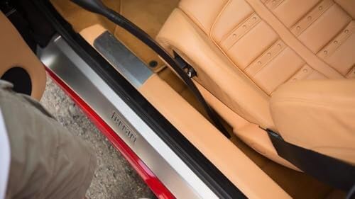 Person vacuuming car carpet with a wide nozzle attachment