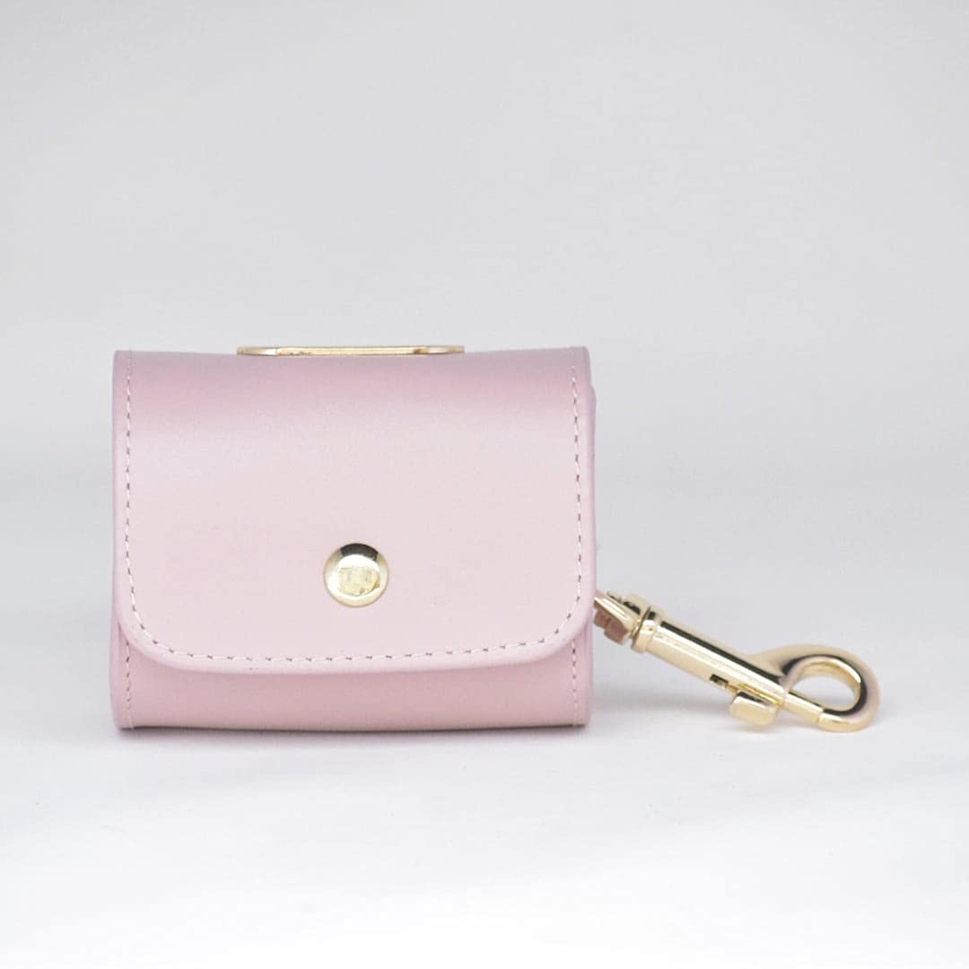 Distributeur de sacs à déjections canines en cuir rose compact contre les rouleaux perdus