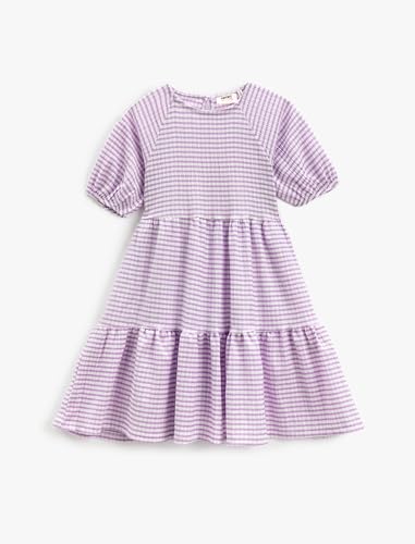 Robe fille Koton au design fluide et col rond, un vêtement aux finitions soignées pour enfant.