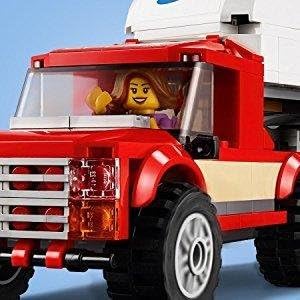 LEGO minifigure seated in the driver's seat of the red pickup truck.