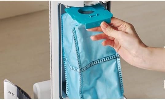 Hand removing a blue dust bag from the automatic emptying station of the EZIclean Cyclomax R22 Station.