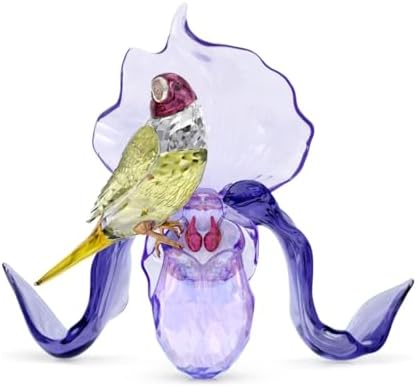 Swarovski Idyllia Gouldian Finch and Orchid crystal figurine on a dark surface.