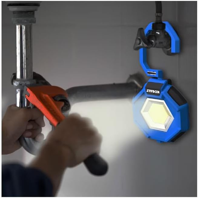 Kobalt work light illuminating a plumbing repair under a sink, showcasing its practical use in tight spaces.
