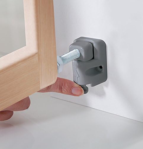 A finger pressing the release button on the gate's latch mechanism to open it.
