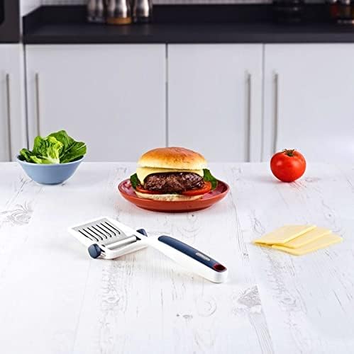 The Zyliss cheese slicer on a kitchen counter next to a burger and cheese slices, demonstrating its use for sandwiches.
