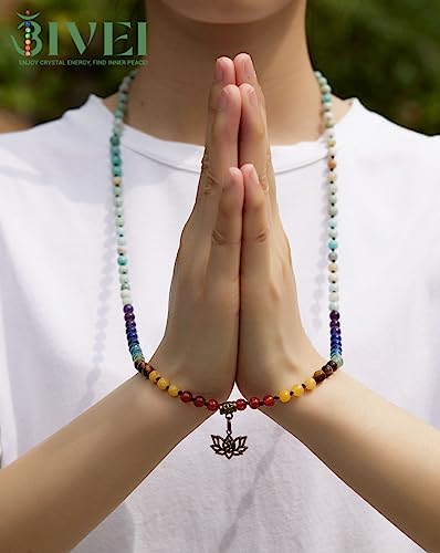 Person wearing a multicolored beaded necklace with a lotus pendant