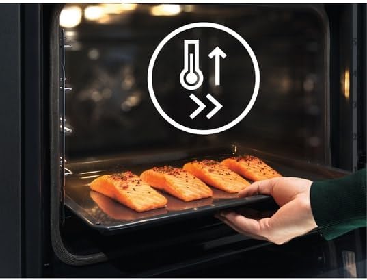 Hand sliding a baking tray with salmon fillets into the oven on telescopic rails