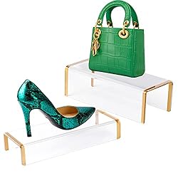 a green purse and green shoe on two clear stands with gold legs.