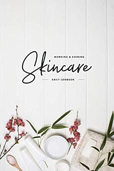 White morning and evening skincare logbook beside flowers and cosmetic jars