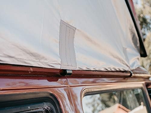 Close-up of a side attachment point on the rainfly, showing how it secures to the vehicle's body.