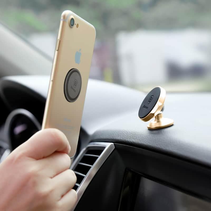 Hand attaching a smartphone with a metal plate to the magnetic car holder
