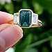 SilverQ 2 Ct Emerald Cut Green Diamond Three Stone Engagement Ring for Women 14K Yellow Gold Plated Bezel Set Trilogy Ring with Baguette Side Stones 925 Sterling Silver Handmade Classic Jewelry