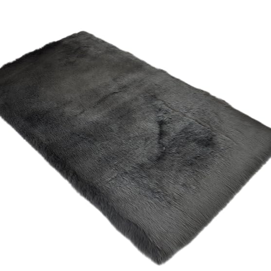 Tapis en peluche gris foncé comme descente de lit douillette dans une chambre