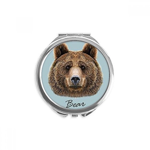 Miroir de poche à la main ours brun pour retouche maquillage en déplacement