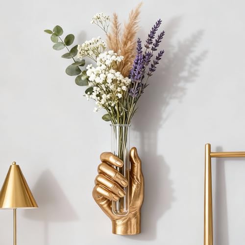 A life-size gold resin hand jutting from your wall, clutching a glass test tube vase — maximalist, surrealist, and genuinely conversation-stopping.