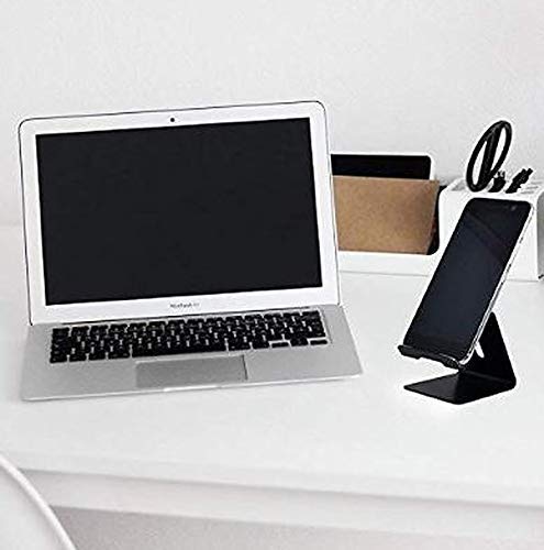 Mobile phone stand on a desk next to a laptop