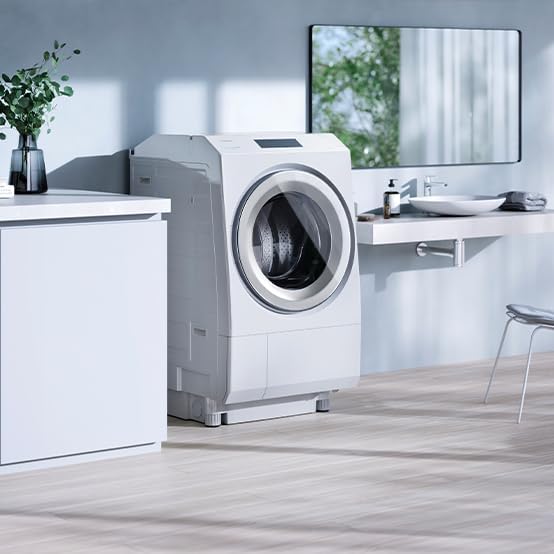 Side view of the Toshiba TW-127XP4L-W washer dryer in a room, showing its depth and integration with cabinetry.