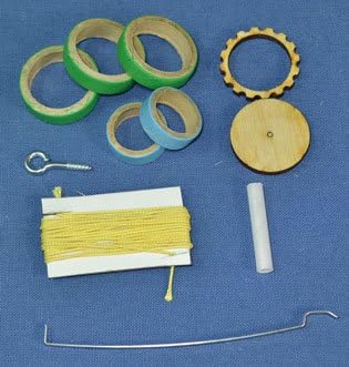 Small components for the SkyMetra rocket kit, including tape, eye hook, and wooden parts