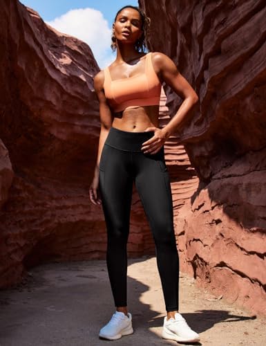 Woman wearing black full-length athletic tights with a sleeveless top outdoors.