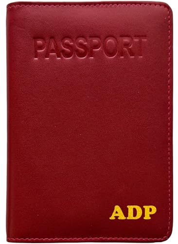 a red leather passport cover standing upright beside a folded boarding pass