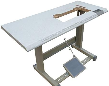 Assembled industrial sewing machine table with foot pedal.
