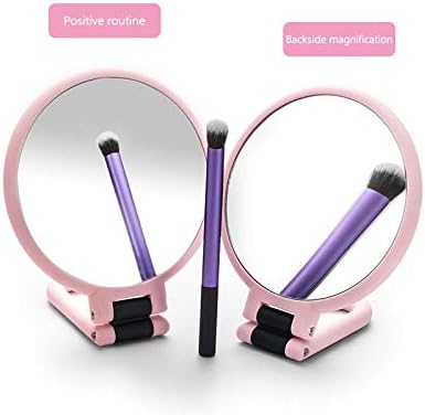 Two SUNESA folding makeup mirrors, one showing a standard reflection and the other showing a magnified reflection, with a makeup brush in front of them.