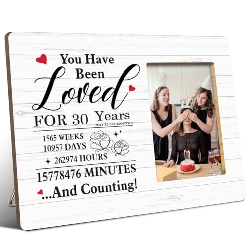 a wooden picture frame with a printed sentimental message, displayed on a shelf with a photo inside