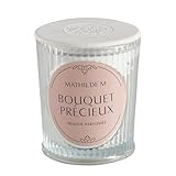 Découvrez le parfum Bouquet Précieux, une composition florale éclatante imaginée comme un précieux écrin de fleurs blanches. Elle signe le mariage du sublime jasmin et de l'onctueuse tubéreuse, enveloppés des douces notes de santal et vanille.Véritable objet de décoration, cette bougie Les Intemporelles parfume agréablement à chaud comme à froid. Son écrin de verre côtelé est coiffé d'un élégant couvercle en plâtre réalisé à la main et marqué du sceau Mathilde M. Elle possède une mèche 100% coton et est composée d'une cire de haute qualité, mélange équilibré de cire végétale de soja et de cire minérale pour garantir un parfumage optimal. Allumée, elle crée instantanément une ambiance cha...