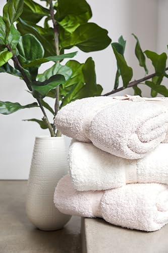 Stone-colored Barefoot Dreams CozyChic throw blanket beside a living-room chair