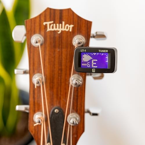 Pudełko prezentowe z akcesoriami gitarowymi [marki Guitar Lab], metalowa puszka zawiera pasek do gitary, kapodaster, elektroniczny tuner i puszkę, idealne dla miłośników gitary i uczących się gry