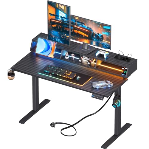 OffiGo Mesa Gaming, Escritorio Elevable con LED RGB y Enchufes, Electrico Mesa Regulable Altura con 3 Espacios Abiertos, Portavasos y Gancho para Auriculares, Fibra de Carbono, Negro