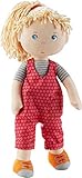 Die rote Latzhose kann per Klettverschluss einfach an- und ausgezogen werden und passt auch anderen 30 cm großen HABA Stoffpuppen