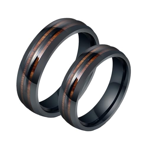 Bague de fiancaille couple acier symbole d'amour éternel texture bois noir