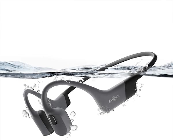 Shokz OpenSwim Pro headphones partially submerged in water, demonstrating its waterproof capability.