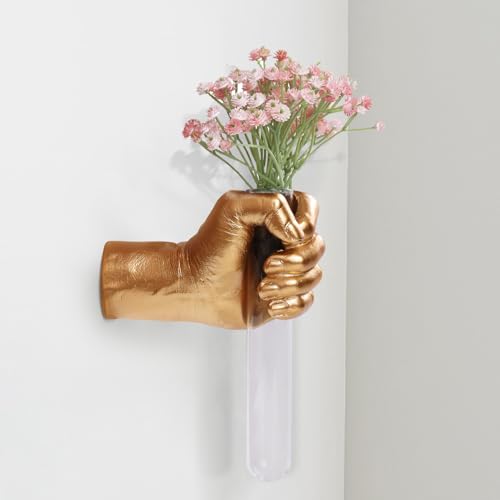 A wall-mounted sculptural hand holding a test tube bud vase — half art piece, half functional, fully conversation-starting.