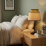 Lampe de table Alpinaluz au design contemporain combinant un double abat-jour: un grand en ratan naturel apportant texture et chaleur, et un petit en tissu vert qui ajoute une touche de fraîcheur et de couleur à tout espace intérieur.