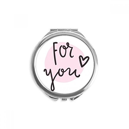 Miroir rond maquillage de poche portable à la main avec reflet net et design rose compact