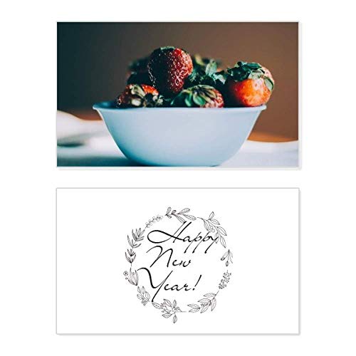 Fotografía de fruta con fresas seleccionadas y tarjeta con mensaje de Año Nuevo