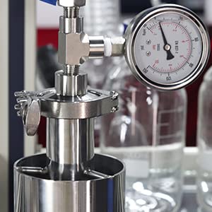 Close-up of the vacuum gauge and connection point on the stainless steel tube, showing a clamp and the top of the tube.